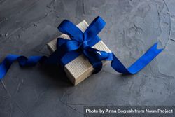 Single gift box with blue ribbon on concrete 5z3jQ4
