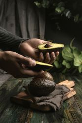 Person hands holding avocados