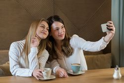 Young women taking selfie in cafe