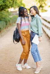 Female friends in casual clothing in park walk way