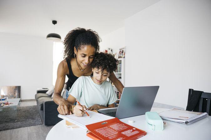 Girl doing her homework with mother