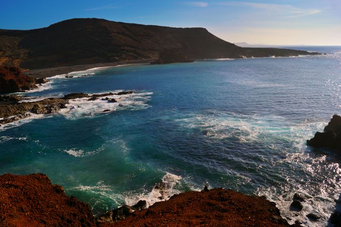 Beautiful and picturesque view of surface of sea water among high rocky cliffs on sunny day