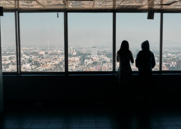 Back of two women enjoying view of Mexico City on hazy day