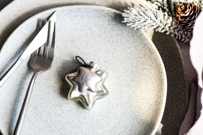 Silver table setting for Christmas dinner with star ornament