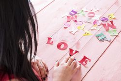 Shot of the back of woman touching paper letters and the word love