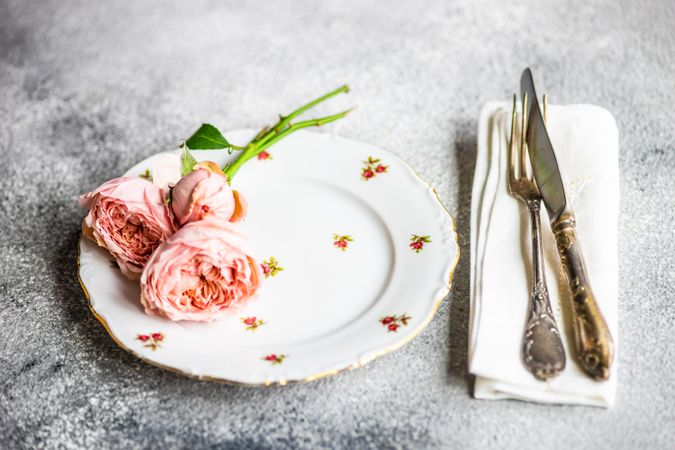 Floral card with pink roses on delicate table setting on grey counter