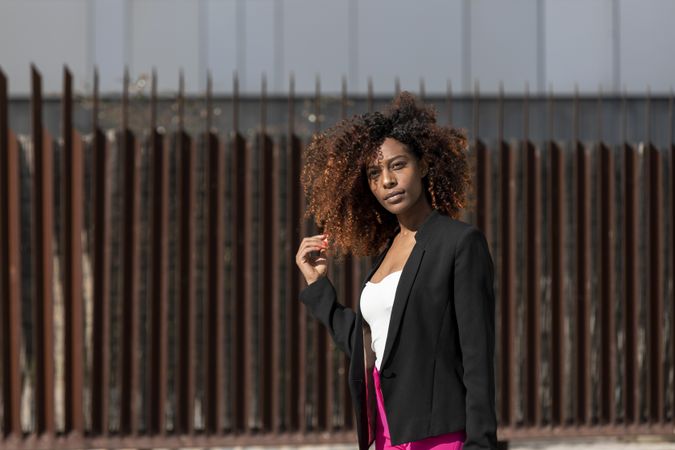 Black female standing in front of brown wall in the sunshine
