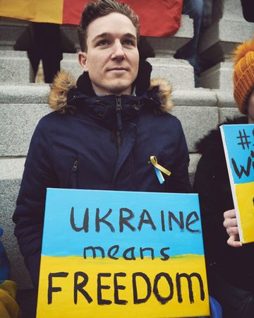 London, England, United Kingdom - March 5 2022: Man with “freedom” sign in Ukrainian flag colors