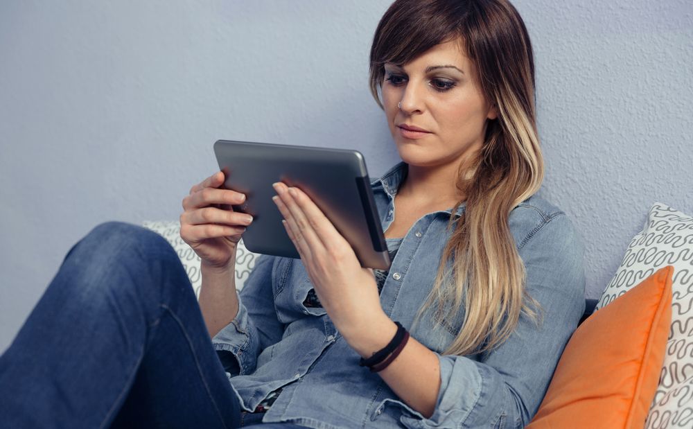Woman relaxing reading a tablet in bed