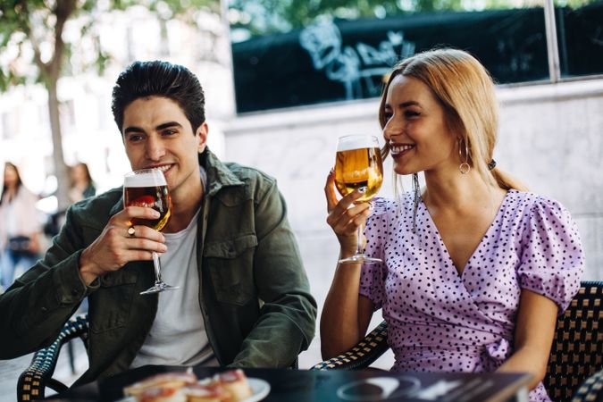 Happy young couple drinking beverages outdoors