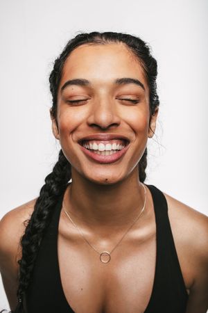 Beautiful young female athlete smiling with eyes closed