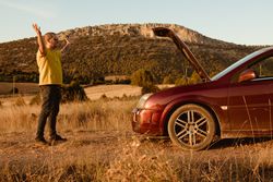 Annoyed man near broken car in countryside