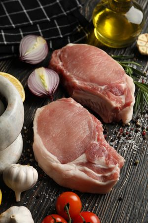 Composition with raw meat for steak and ingredients on wooden background