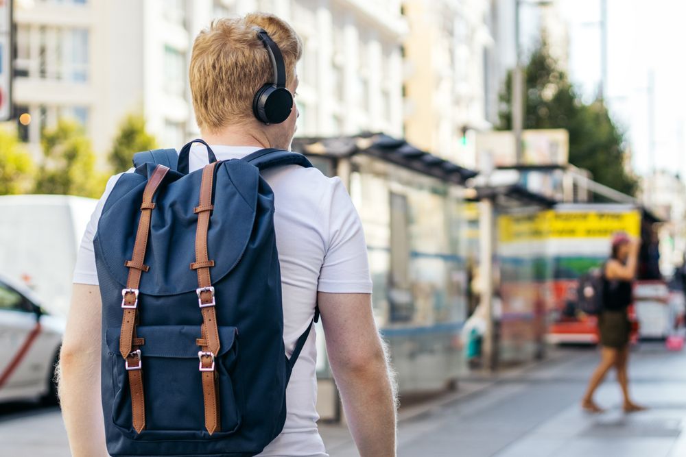 Latino man with albinism strolling down the street in light clothes