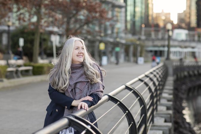 Smiling woman leaning on a railing outside
