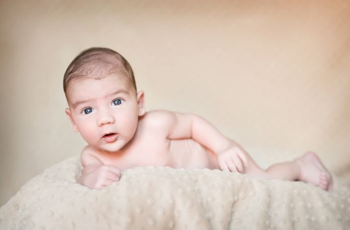 Portrait of newborn baby lying down over a blanket