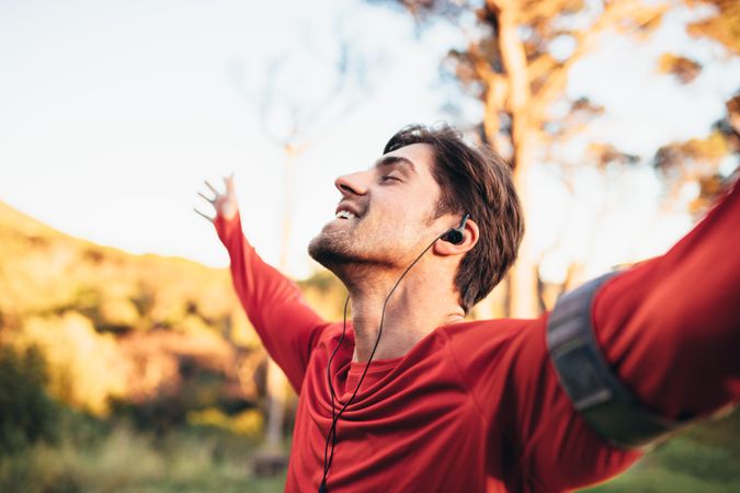 Man enjoying nature while listening to music in a park