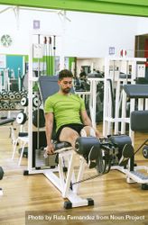 Male in green t-shirt working out quads on leg machine 0L8wA0