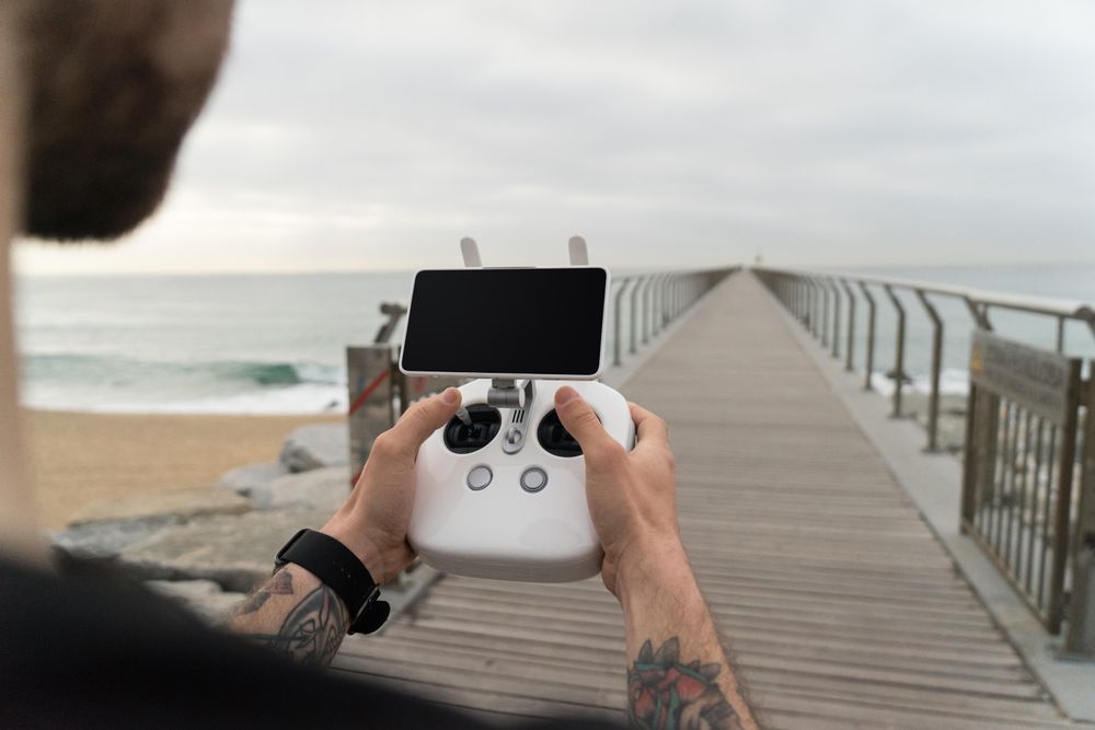 Man holding remote on boardwalk
