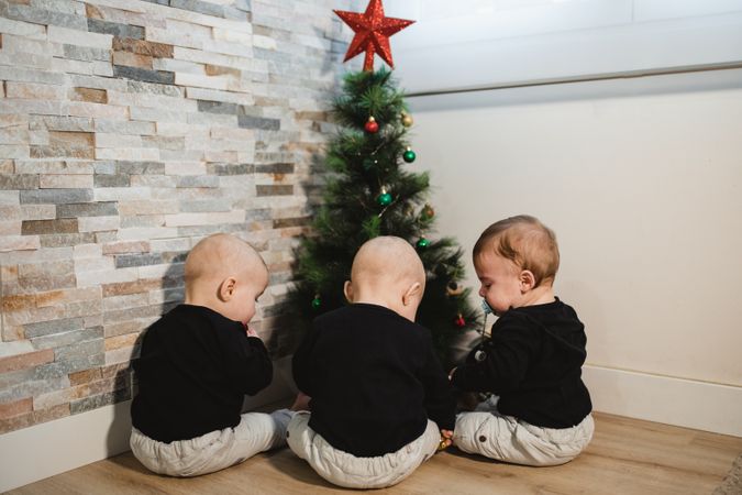 Anonymous babies near Christmas tree
