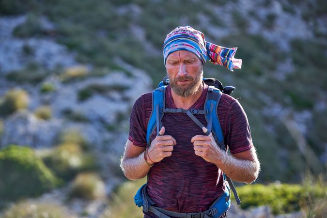 Male hiker with backpack on hillside