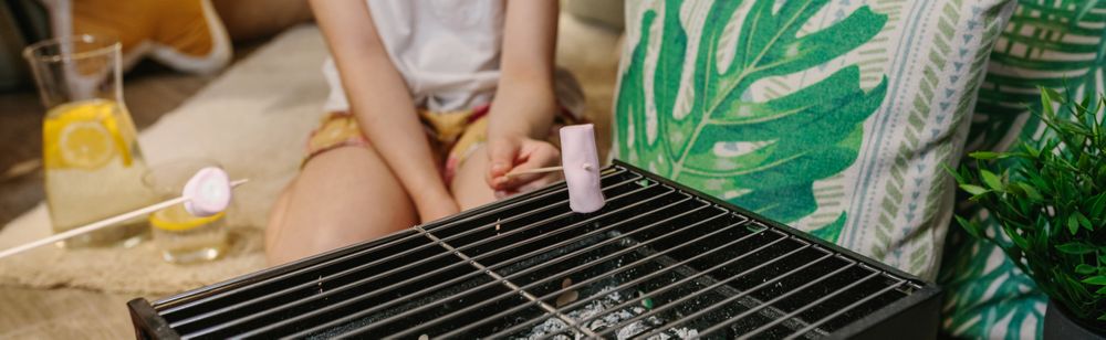 Girl camping at home roasting marshmallows
