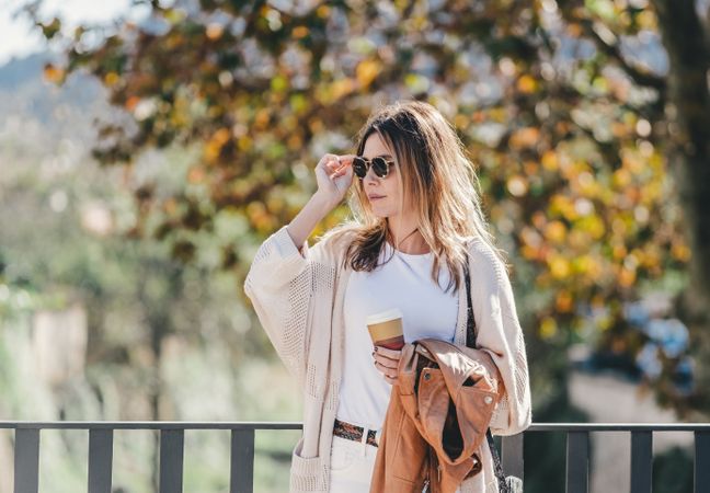 thoughtful woman leaning on handhold and looking along
