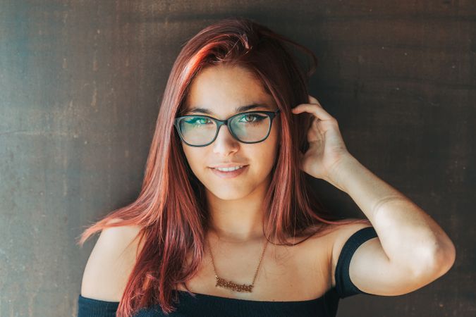 Woman in glasses leaning on wall