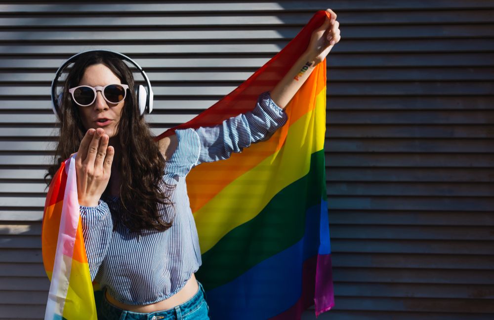 Woman posing happily with the LGBT flag