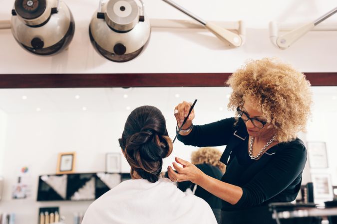 Female hairstylist setting hair in fashionable design