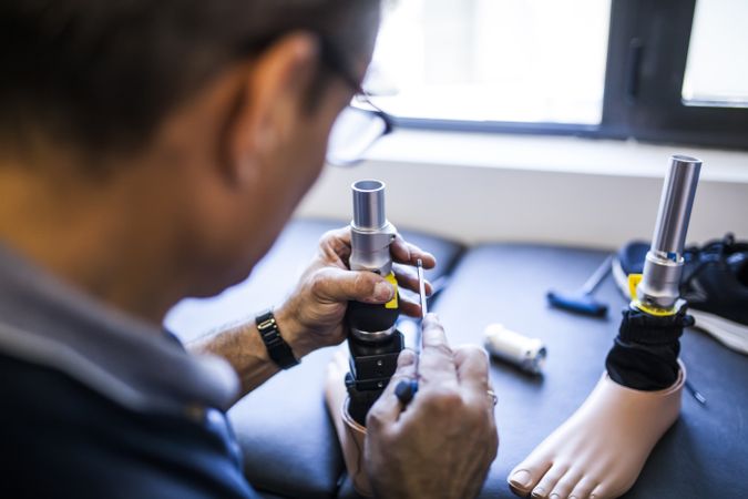 man fixing a prosthesis in a workshop