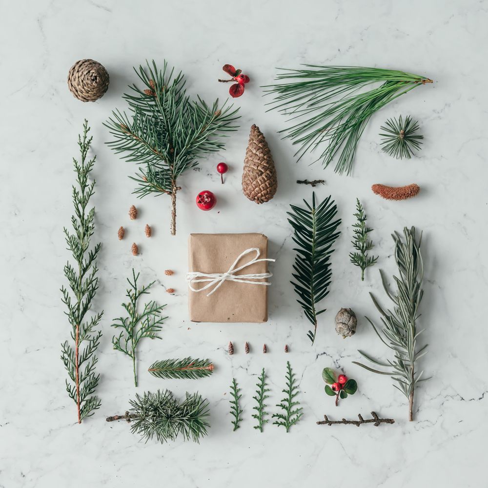 Creative layout made of winter branches, on marble background with present