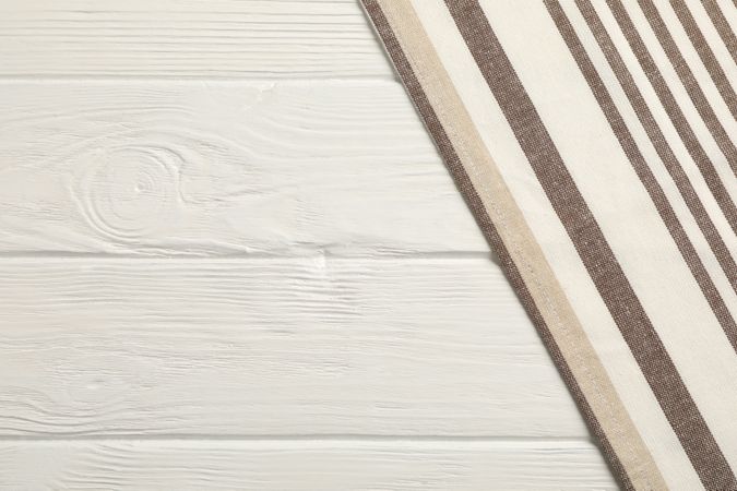 Fabric napkins on wooden background, space for text