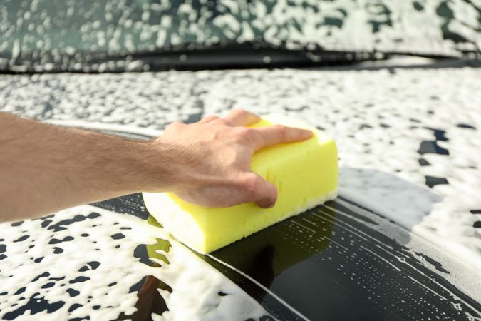 Man wipes the car with a sponge. Car wash. Clear car concept