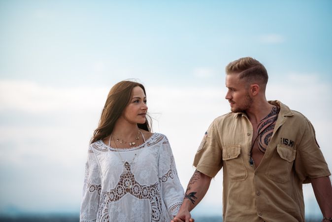 adorable couple walking on an amazing beach holding hands