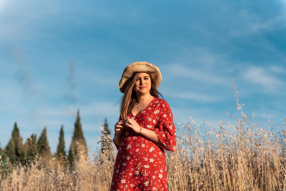 Happy dreamy woman standing among high grass
