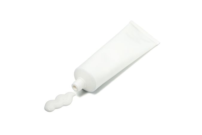 Blank tube with toothpaste isolated on light background