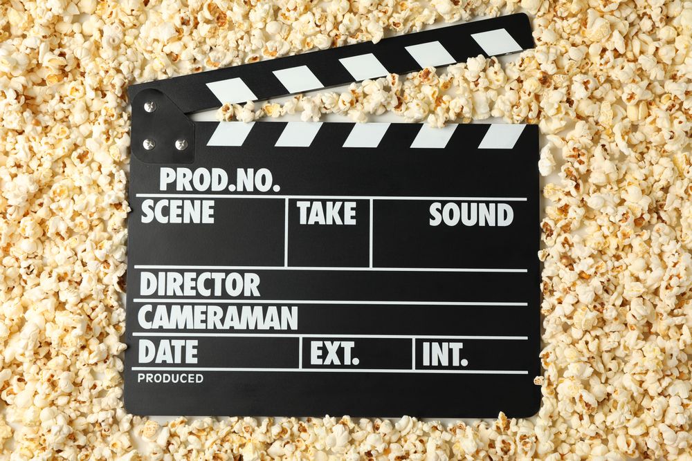 Clapperboard and many popcorn, top view