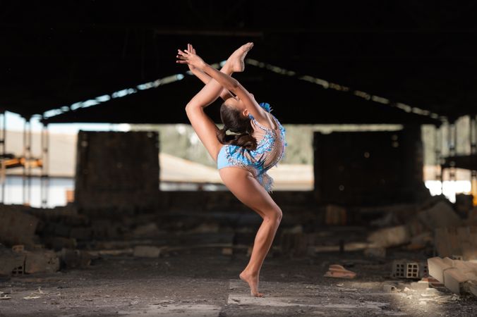 Young girl performing rhythmic gymnastics exercises outdoors