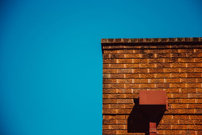 Red Brick Wall In Strong Sunlight Against A Clear Blue Sky