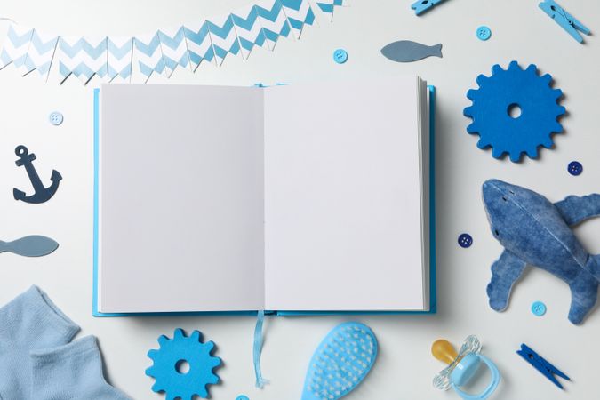 Blue children's book, with toys, on a light background.