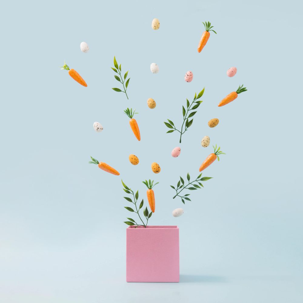 Spring leaves, Easter eggs and carrots coming out of pink box