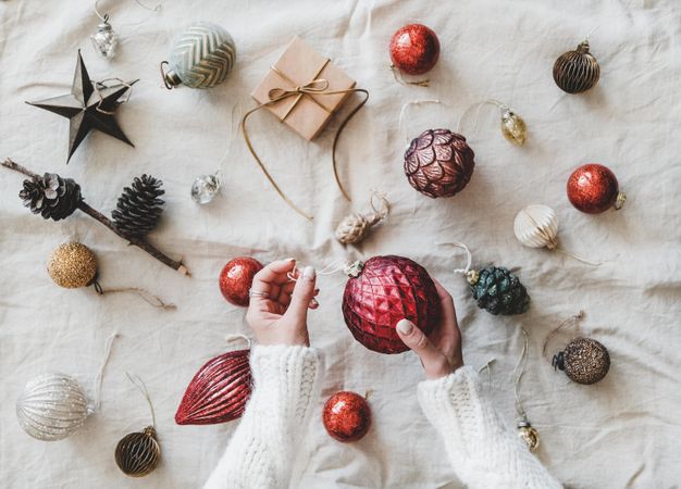 Flat-lay of holiday decoration, with hands, top view