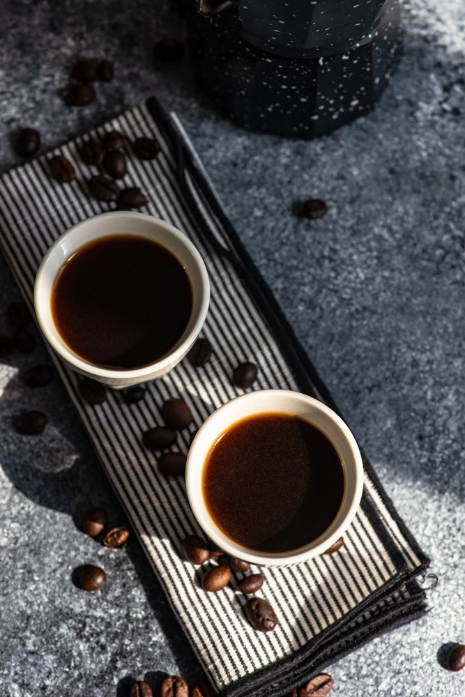 Top view of two shots of espresso on towel on kitchen counter