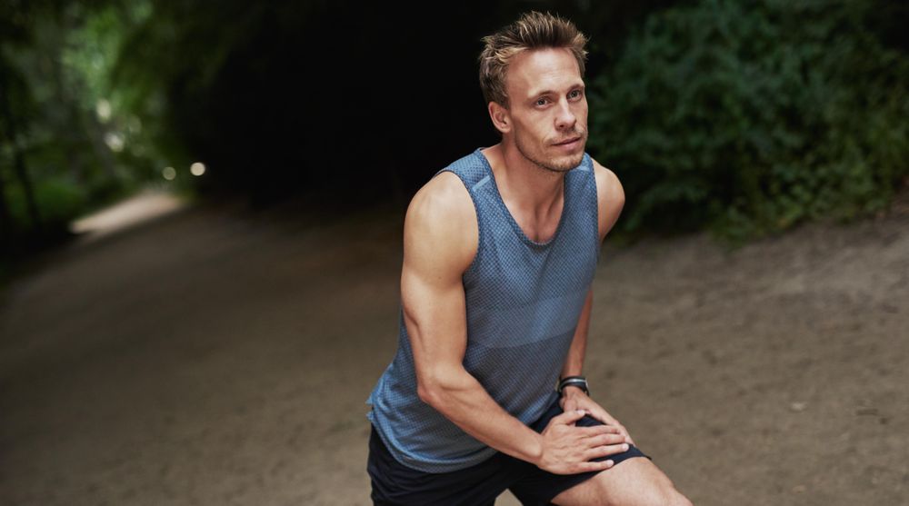 Man in sportswear stretching his quads