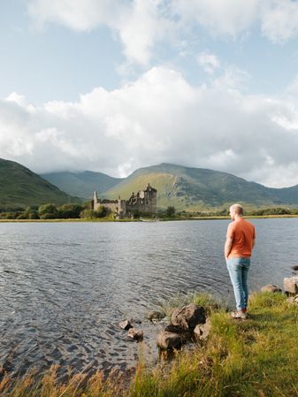 Male tourist standing on lake shore