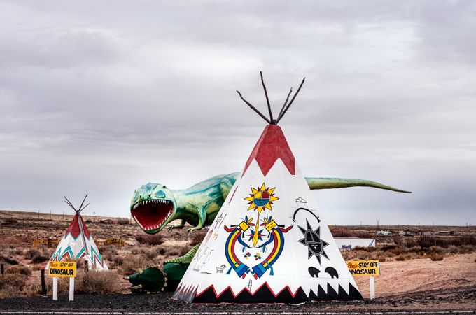 Dinosaur statue and Native American tipis at off-road tourist attraction in Arizona