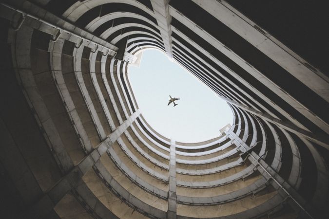 Bottom view photo of airplane passing over a building
