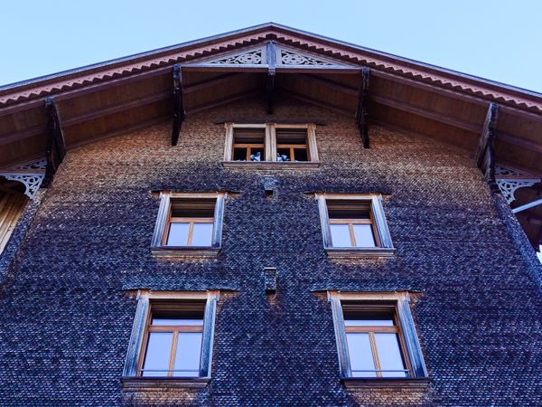 Traditional Swiss chalet facade covered in fish scale shakes, Saanen