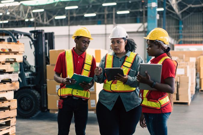 Co workers discussing stock and tasks to complete in distribution center